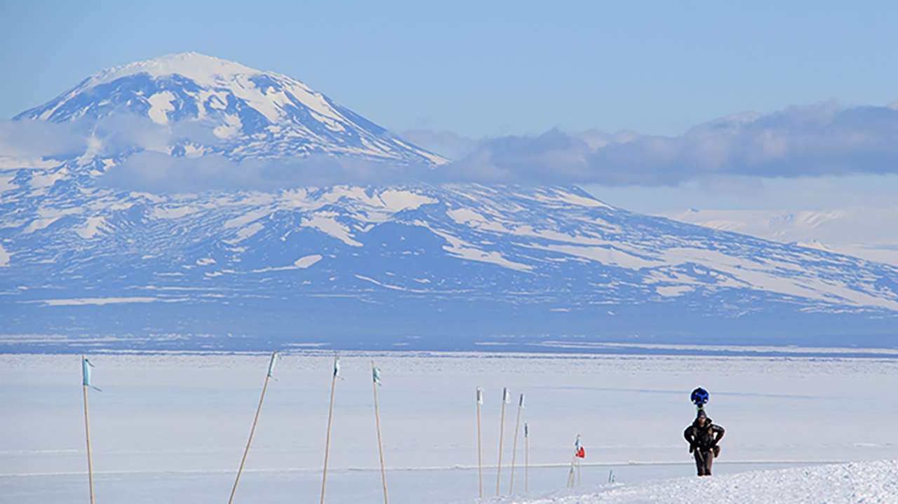 Person walking in the arctic landscape with a large backpack