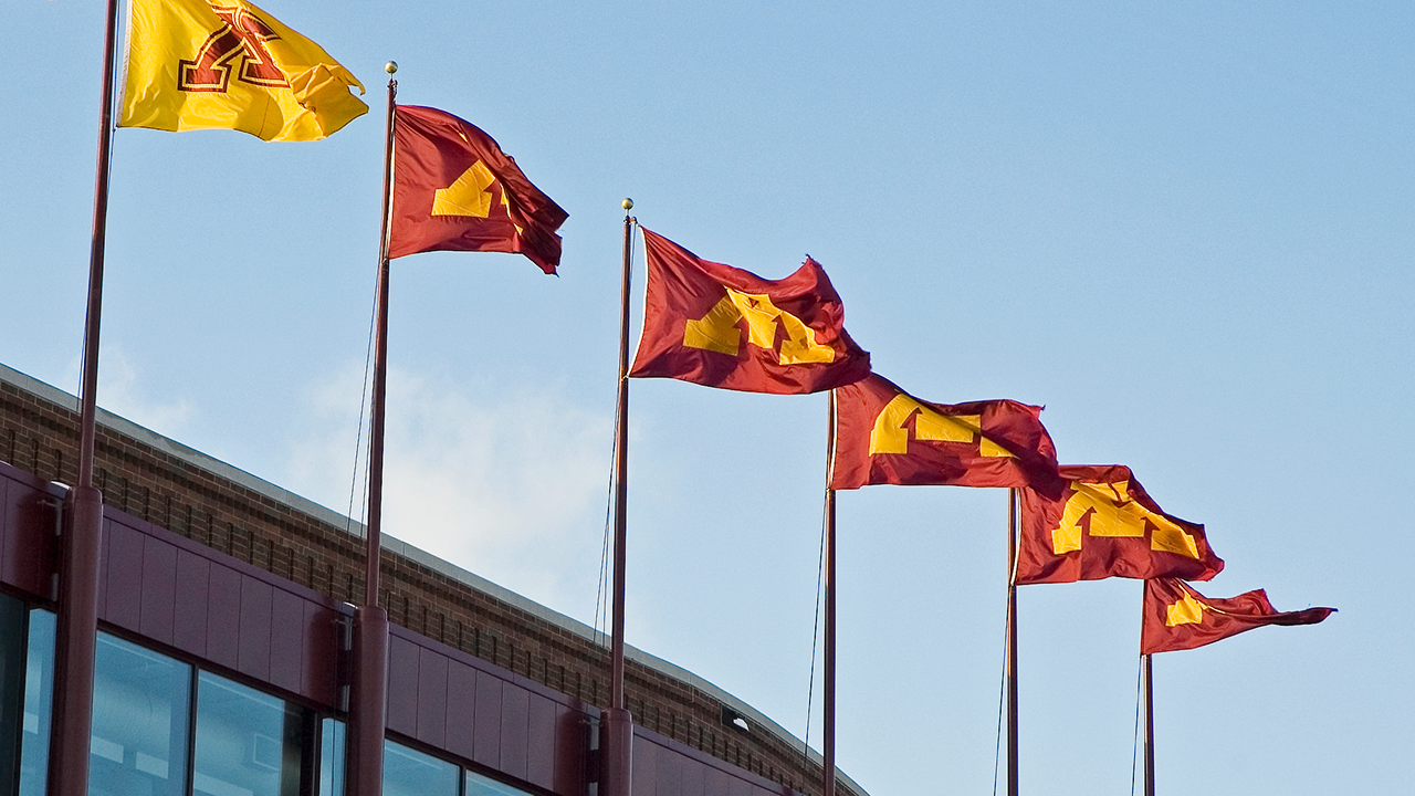 Six UMN flags wave in the sky
