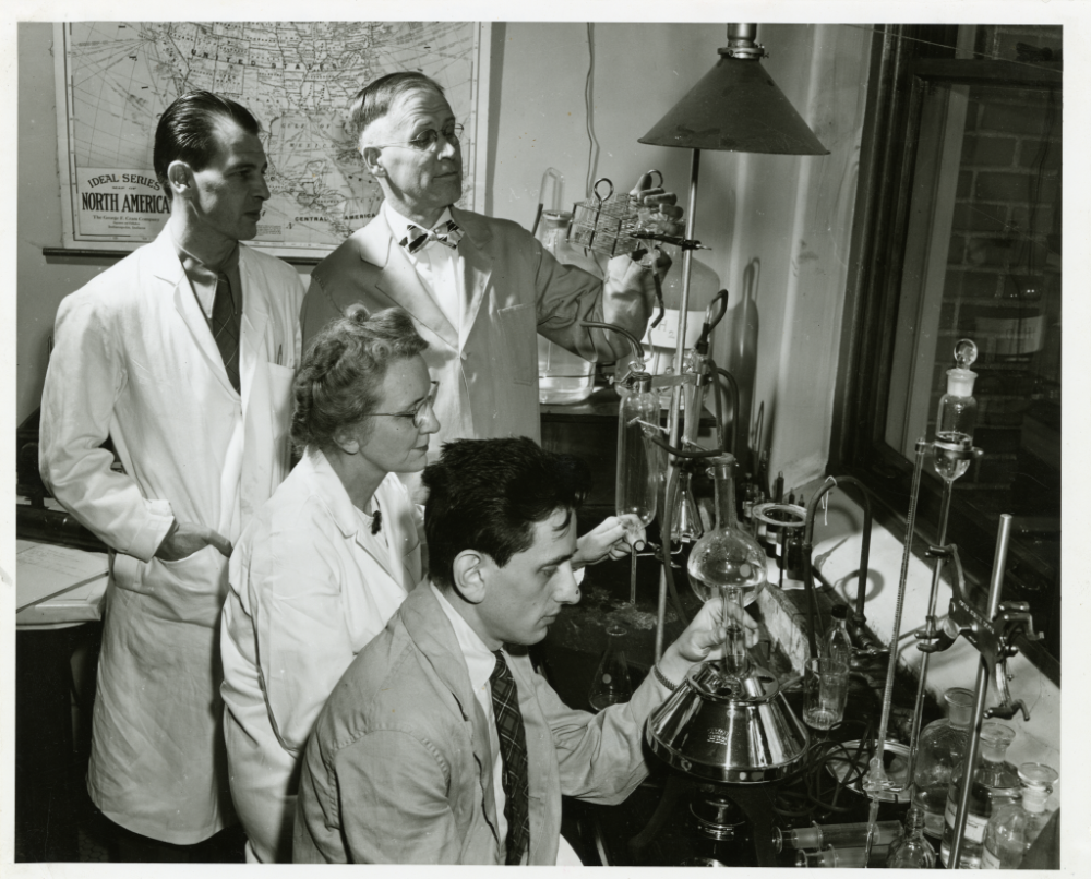 Halvor Halvorson, Cyril Stulberg and Helene Brumfield, gather around laboratory equipment