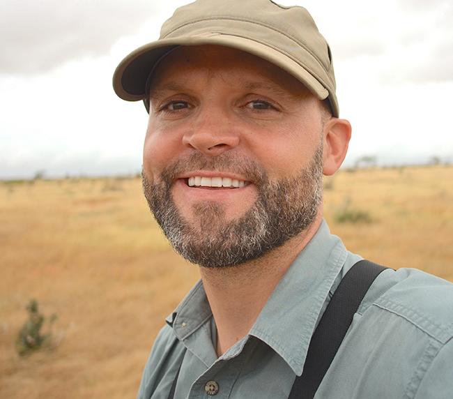 Joseph Bump smiling in front of barren landscape