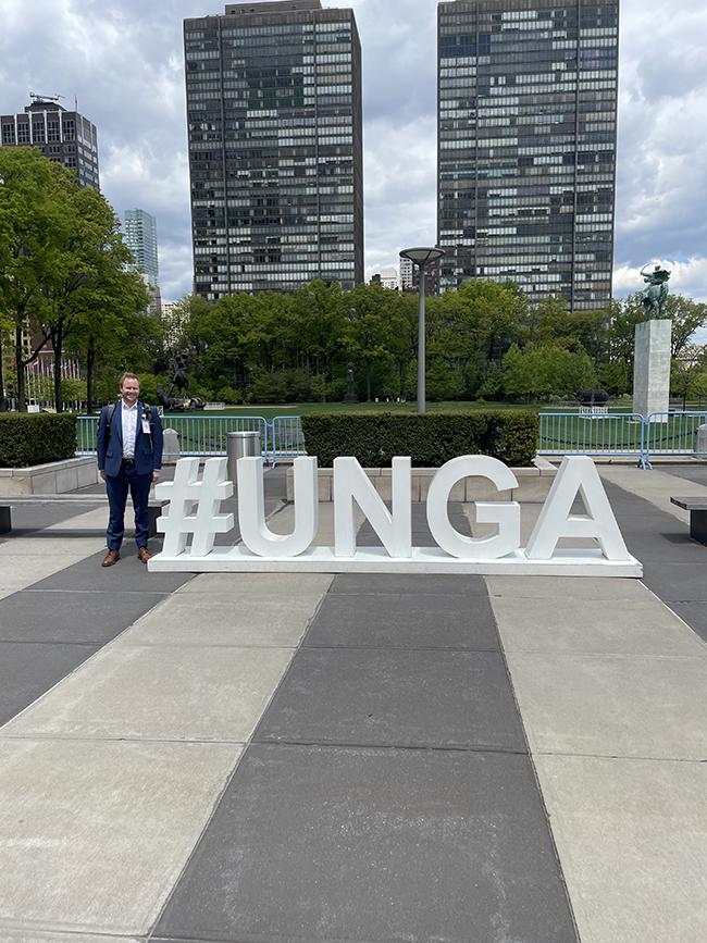 Man stands by sign saying #UNGA