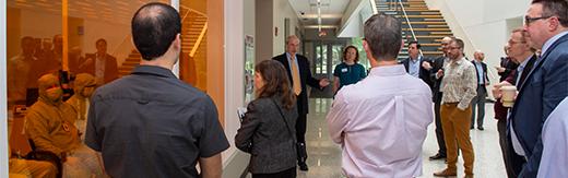 Group standing in front of lab with tinted yellow windows