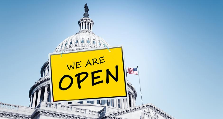 National capital's exterior rotunda with an illustrated sign hanging on it, reading "we are open" 