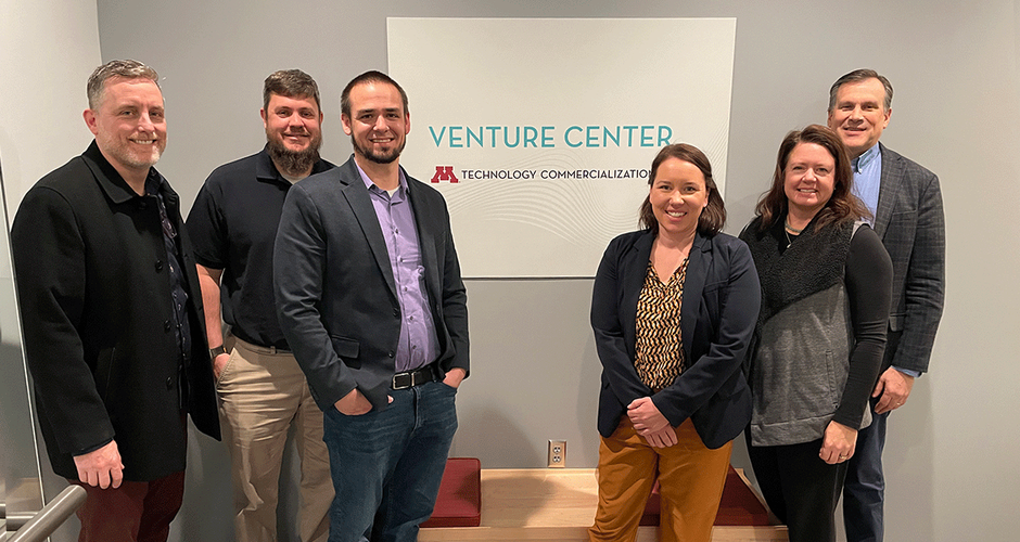 Group of six people stand in front of a "Venture Center" sign