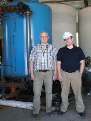 Peter Clevenstine (left) and Igor Kolomitsyn monitor a peat-based filtering system that cleans pollutants from the water used in mining.