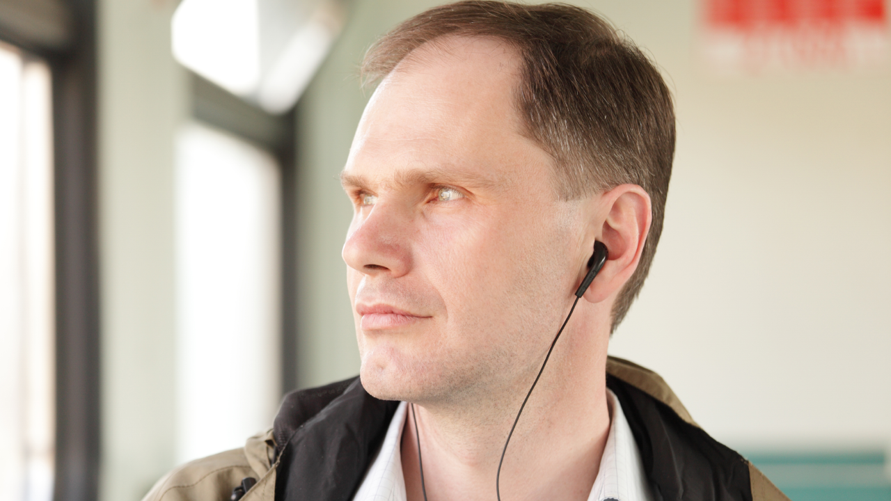 Man listening to a podcast through earphones