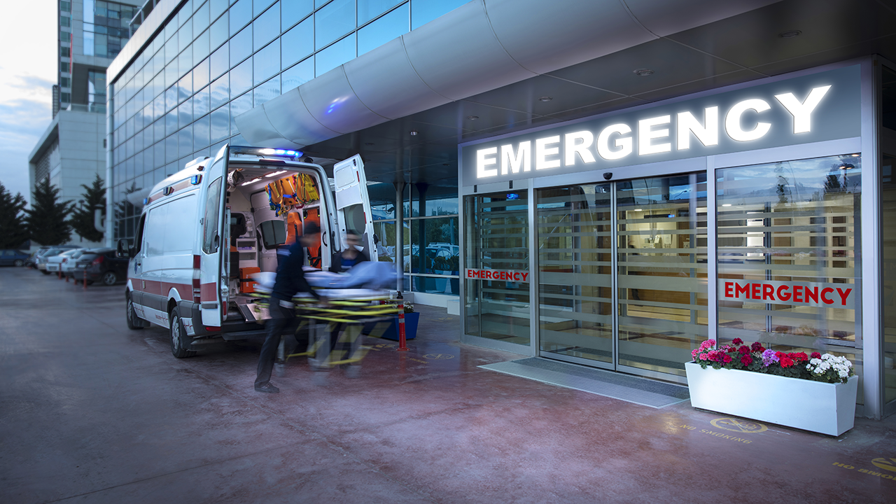 Emergency medical workers arrive at a hospital in an ambulance