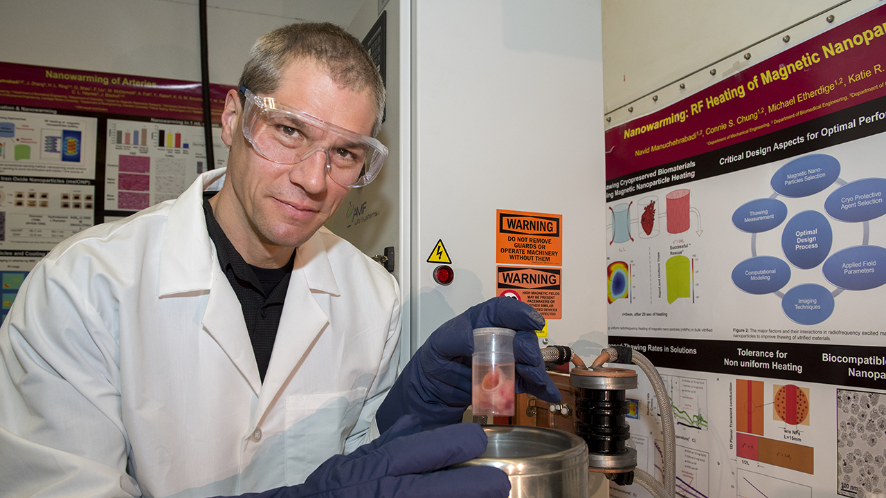 Man in lab coat holding scientific equipment