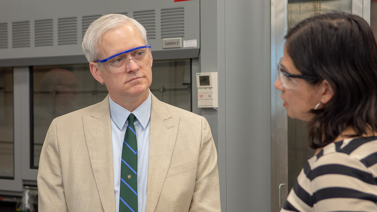 Close up shot of VP Cramer listening to a researcher speak in a laboratory
