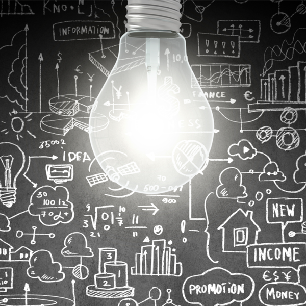 Lightbulb in front of a chalkboard with abstract drawings