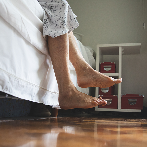 A patient's feet hang over the side of a bed
